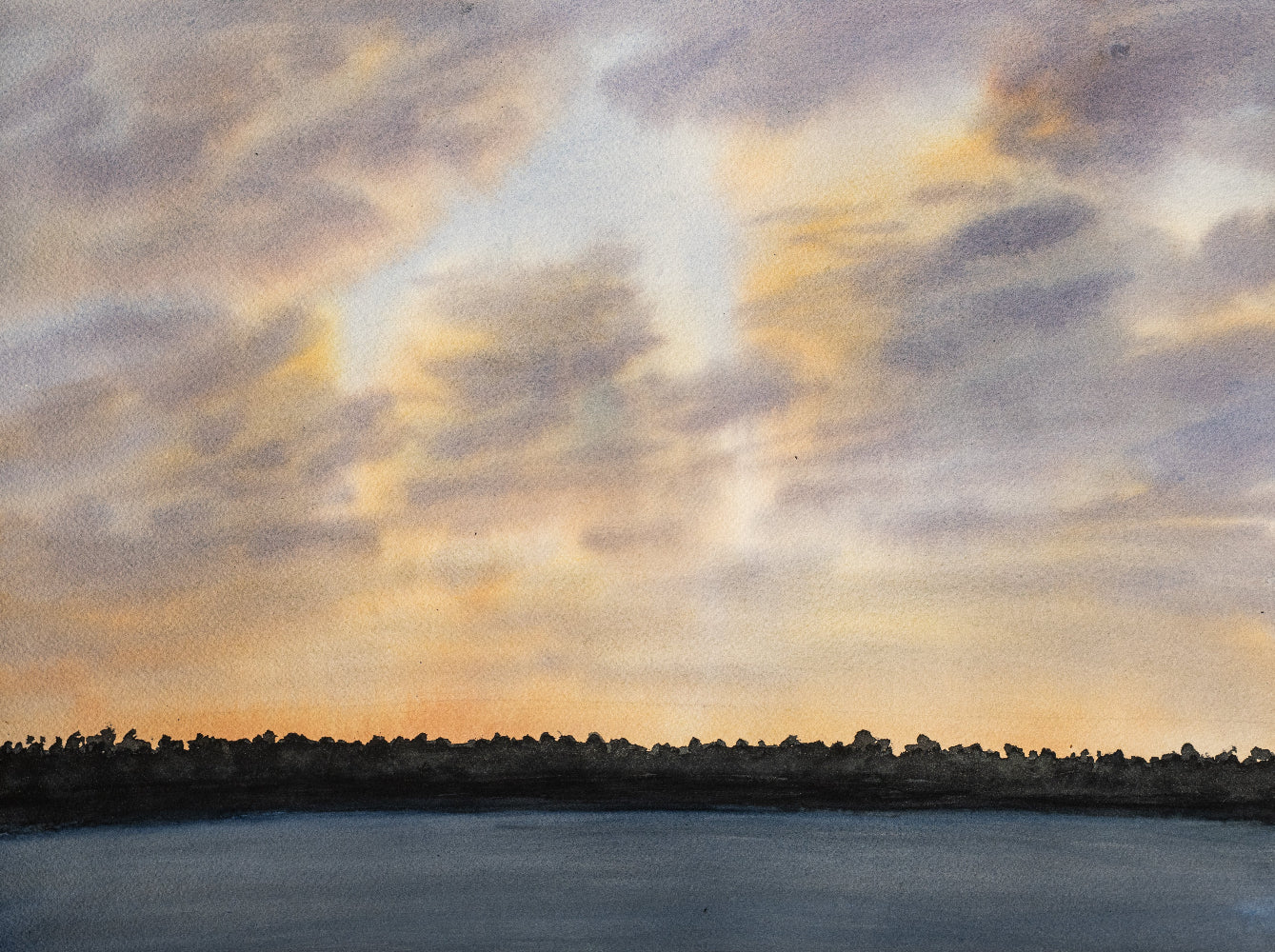 Sunset over a body of water with a city skyline in the distance